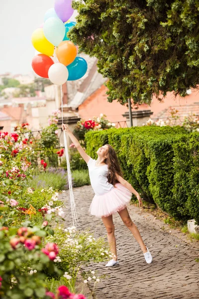 Girl with colorful latex balloons run in the park — Stock Photo, Image