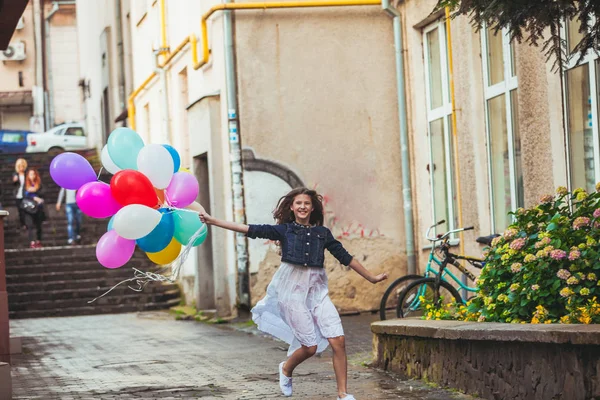 Dívka s barevné balónky v ulicích starého města — Stock fotografie