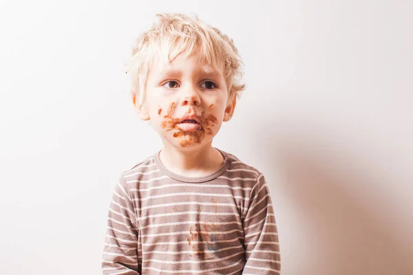 Chlapec v sedě čokolády a mít špinavý obličej — Stock fotografie