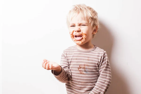 Chłopiec eated czekolady i więcej chce jeść — Zdjęcie stockowe