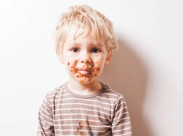 Chico comido chocolate y tener la cara sucia —  Fotos de Stock