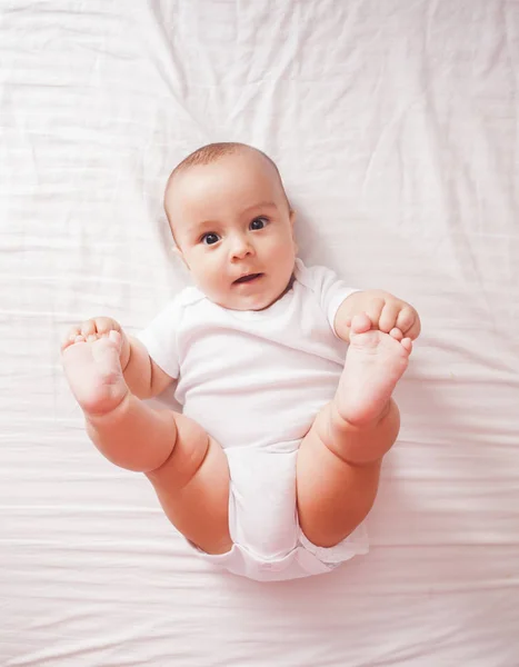 Porträt eines Babys, das auf dem Bett liegt — Stockfoto