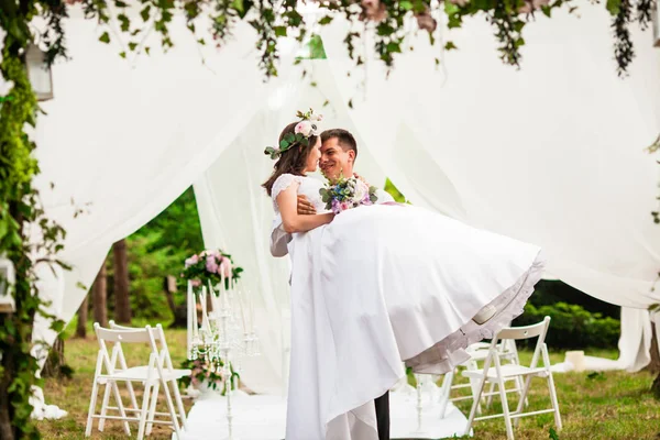 Feliz día de la boda bajo el arco de flores —  Fotos de Stock