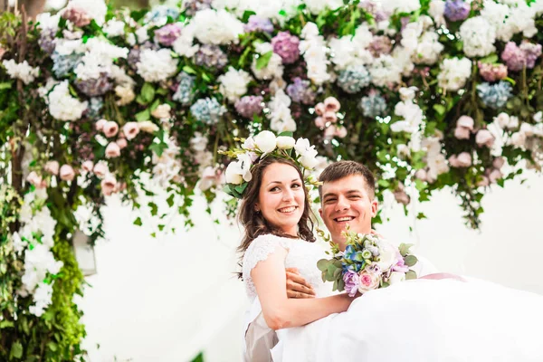 Feliz día de la boda bajo el arco de flores —  Fotos de Stock