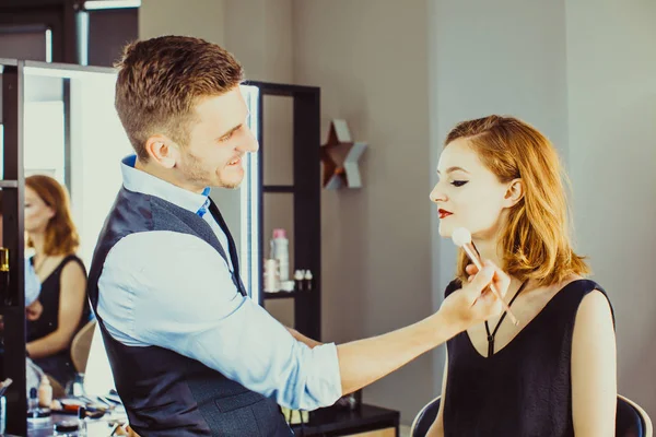 Jonge vrouw in de studio, mens doet make-up — Stockfoto