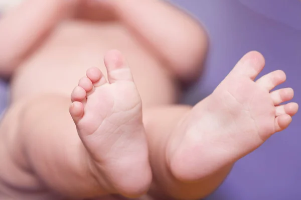 Babys bosé nohy zblízka na modré — Stock fotografie