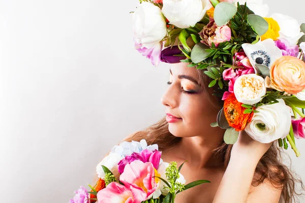 Frühlingsfrau mit buntem Blumenkranz und Strauß — Stockfoto