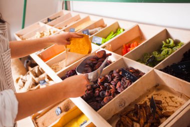 Kadın kurutulmuş aprisots bakkal dükkanı canlı bomba. Ahşap kutular, vegan gıda kuruyemiş