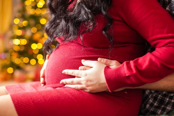 Giovane donna incinta e padre felice la sera di Natale — Foto Stock