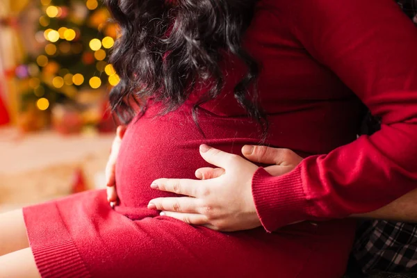 Unga gravid kvinna och lycklig far på kvällen den jul — Stockfoto