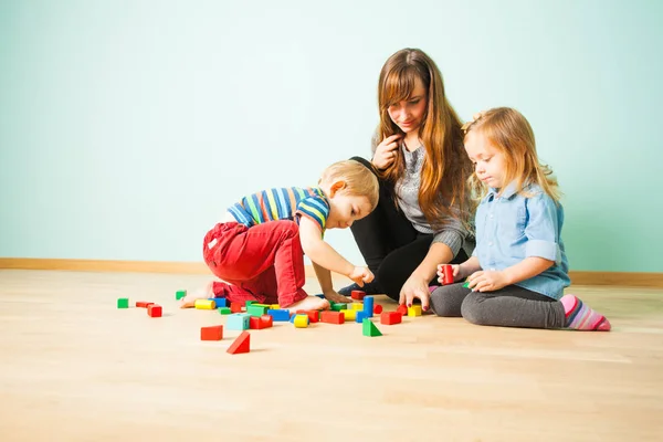 Retrato de família feliz brincando juntos dentro de casa — Fotografia de Stock