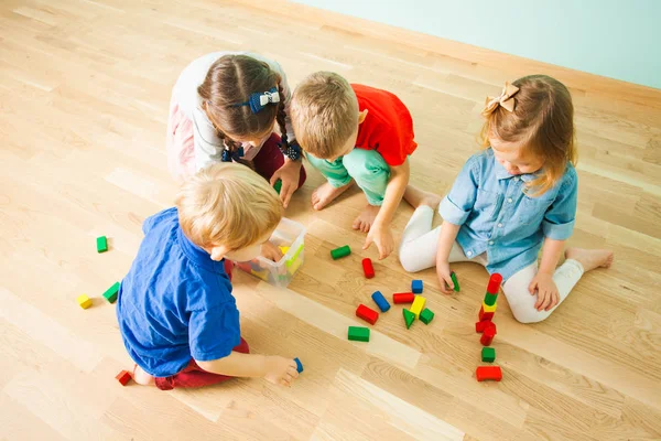 Crianças coletando brinquedos depois de jogar no jardim de infância — Fotografia de Stock