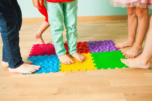 Крупный план детских ног, стоя на специальном коврике для массажа — стоковое фото
