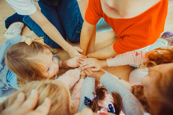 Group of children putting their hands together