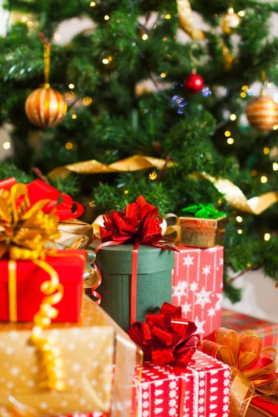 Рождественские подарки куча, огни на елке — стоковое фото