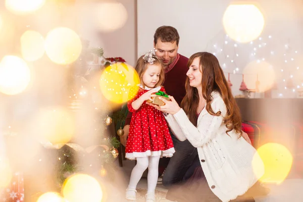 Gelukkig gezin met dochter open het heden op kerstvakantie — Stockfoto