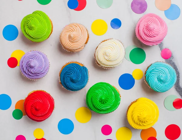 Bunte Regenbogen-Cupcakes mit Konfetti flach legen — Stockfoto