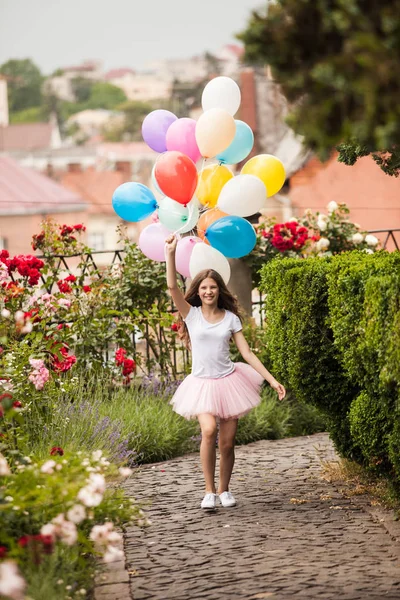 Girl with colorful latex balloons in the park — Stock Photo, Image