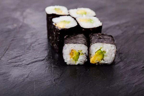 Avocado sushi roll op zwarte leisteen bord — Stockfoto