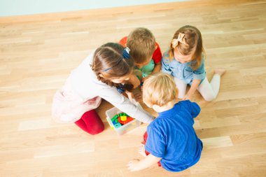 Plastik kutuda oyuncak toplayan dört küçük kardeş