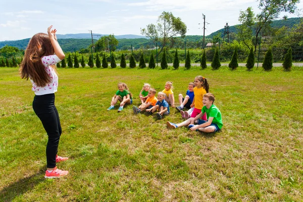 未就学児とチャレードを演奏する若いキャンプリーダー — ストック写真