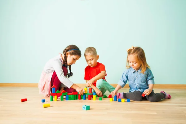 Crianças brincando com blocos coloridos na pré-escola — Fotografia de Stock