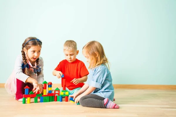 Jeunes enfants construisant des tours à partir de blocs de bois — Photo