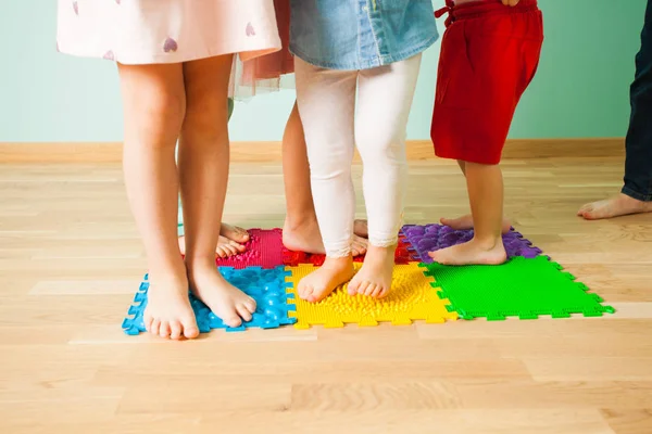 Close-up van kid voeten terwijl je op speciale masseren mat — Stockfoto