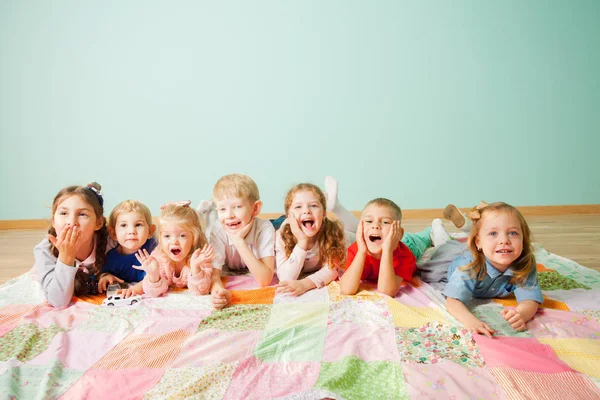 Team van kleine lachende kinderen op een vloer — Stockfoto