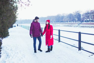 Kar yağışlı şehirde yürüyen çift, kışın romantik bir tarih