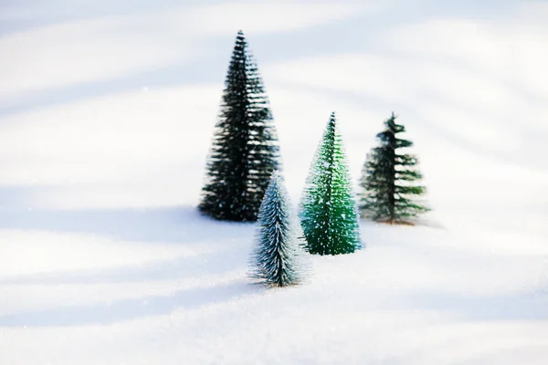 Green artificial christmas trees on untouched snow — Stock Photo, Image