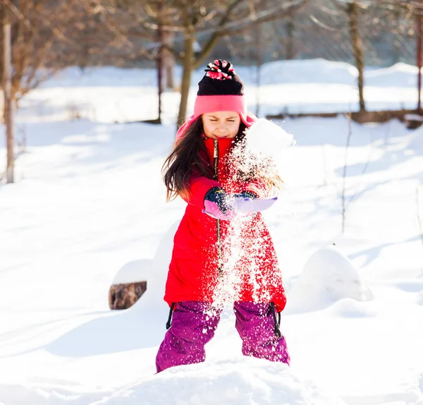 Preciosa chica paleando nieve derramándola alrededor — Foto de Stock