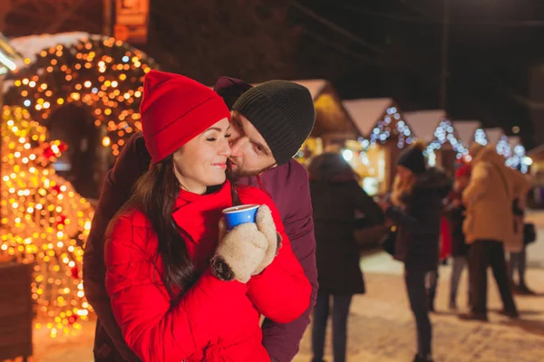 Homem e mulher abraçando, se divertindo na feira de Natal — Fotografia de Stock