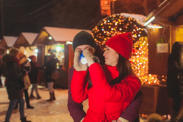 Portret van de vrouw geven van drank aan haar partner op de kerstmarkt — Stockfoto