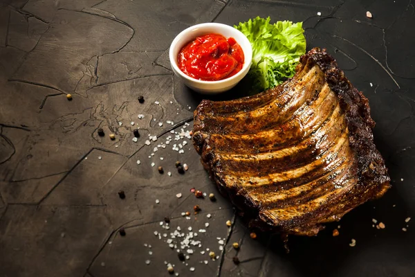 Roasted barbecue pork ribs on the black — Stock Photo, Image