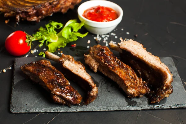 Roasted barbecue pork ribs on the black — Stock Photo, Image
