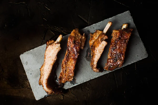 Roasted barbecue pork ribs on the black — Stock Photo, Image