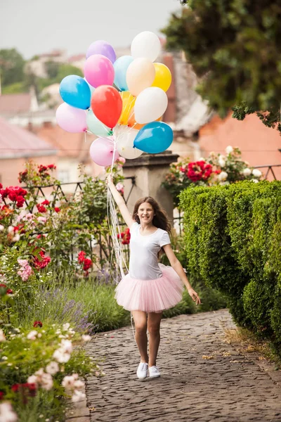 Girl with colorful latex balloons in the park — Stock Photo, Image
