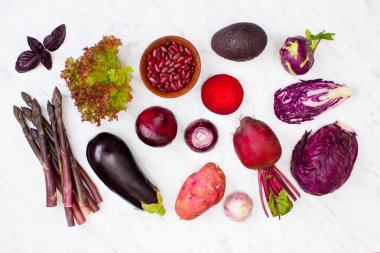Taze çiğ mor sebzeler beyaz mermer üzerinde yatıyordu