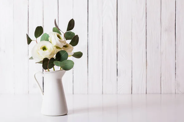 Gestileerde foto van Ranunculus en eucalyptus in vaas — Stockfoto