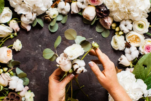 Florista faz um buquê, vista superior sobre a mesa — Fotografia de Stock