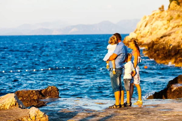 Famiglia felice con i bambini a piedi al tramonto rocce — Foto Stock