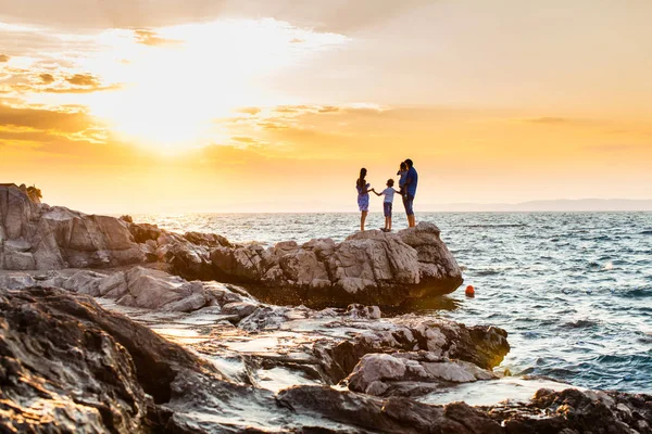 Young family look on the sea on sunset — Stock Photo, Image