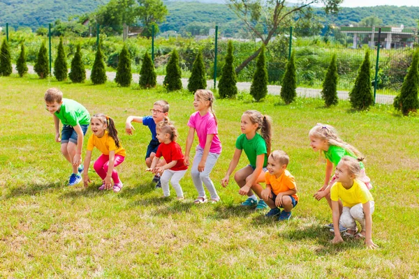 Allegro gruppo di bambini si divertono sull'erba — Foto Stock