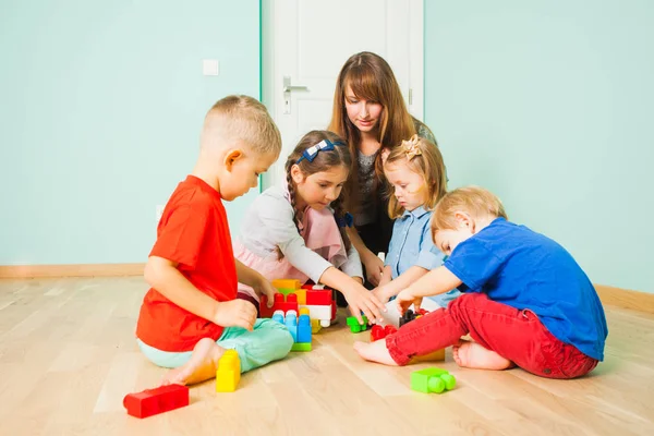 Mãe a brincar com os miúdos, hora do chão. Criança e brinquedos . — Fotografia de Stock