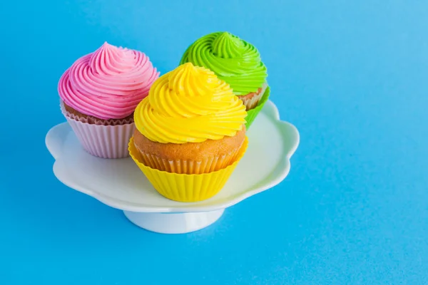 Cupcakes con queso crema en el soporte de pastel blanco —  Fotos de Stock