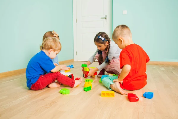 Grupo de niños jugando con bloques de juguetes de construcción — Foto de Stock