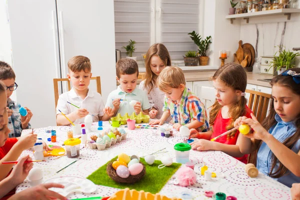 Crianças a pintar ovos. Família feliz se preparando para a Páscoa . — Fotografia de Stock