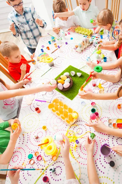 Muchos niños sentados en la mesa y crean decoraciones Ester — Foto de Stock
