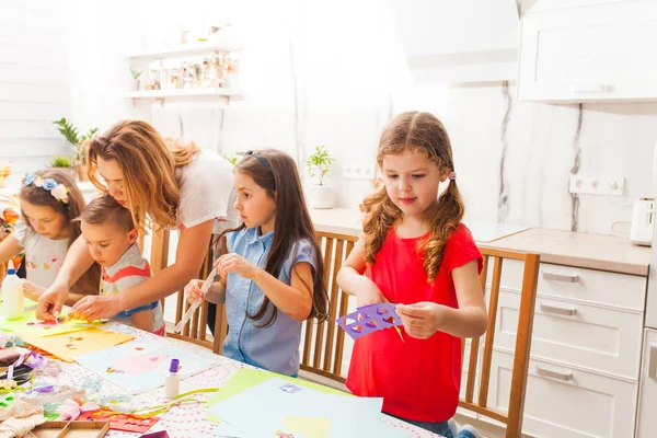 Nauczyciel pomaga dzieciom w projektach artystycznych na wakacje — Zdjęcie stockowe